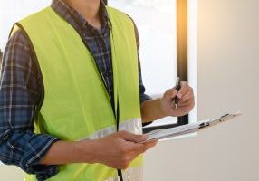 inspector checking structure of new property and taking note in the clipboard for review and fix the house before sell to client